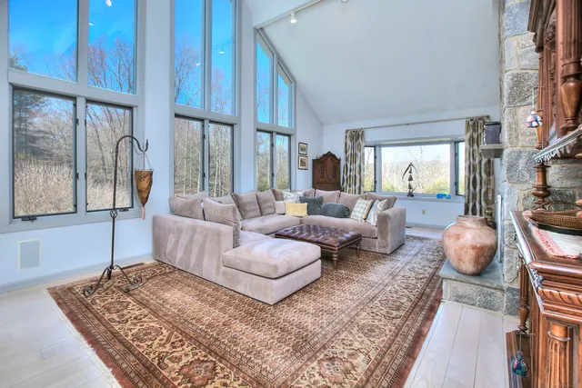 a living room with furniture a large window and a rug