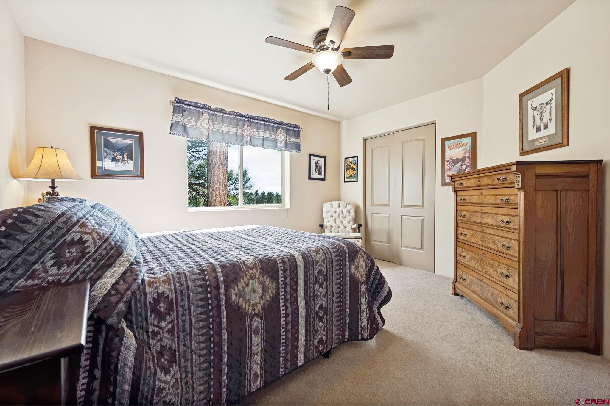 55 Edgemont Way Durango, CO 81301 - Photo 14 of 27 a bedroom with a bed and a chandelier