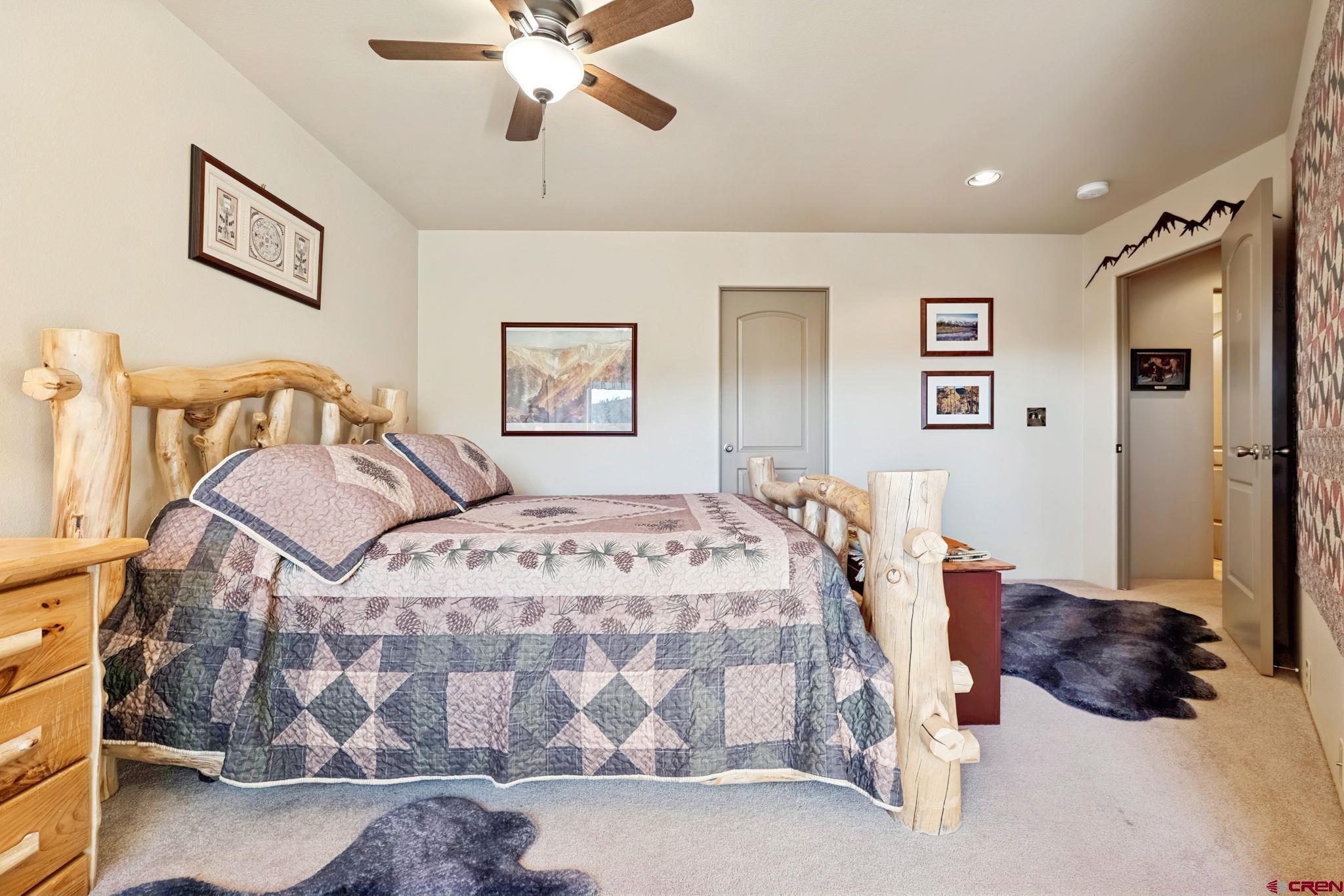 55 Edgemont Way Durango, CO 81301 - Photo 16 of 27 a bedroom with a large bed and a chandelier