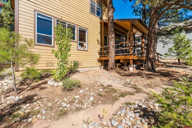 a backyard of a house with barbeque oven table and chairs