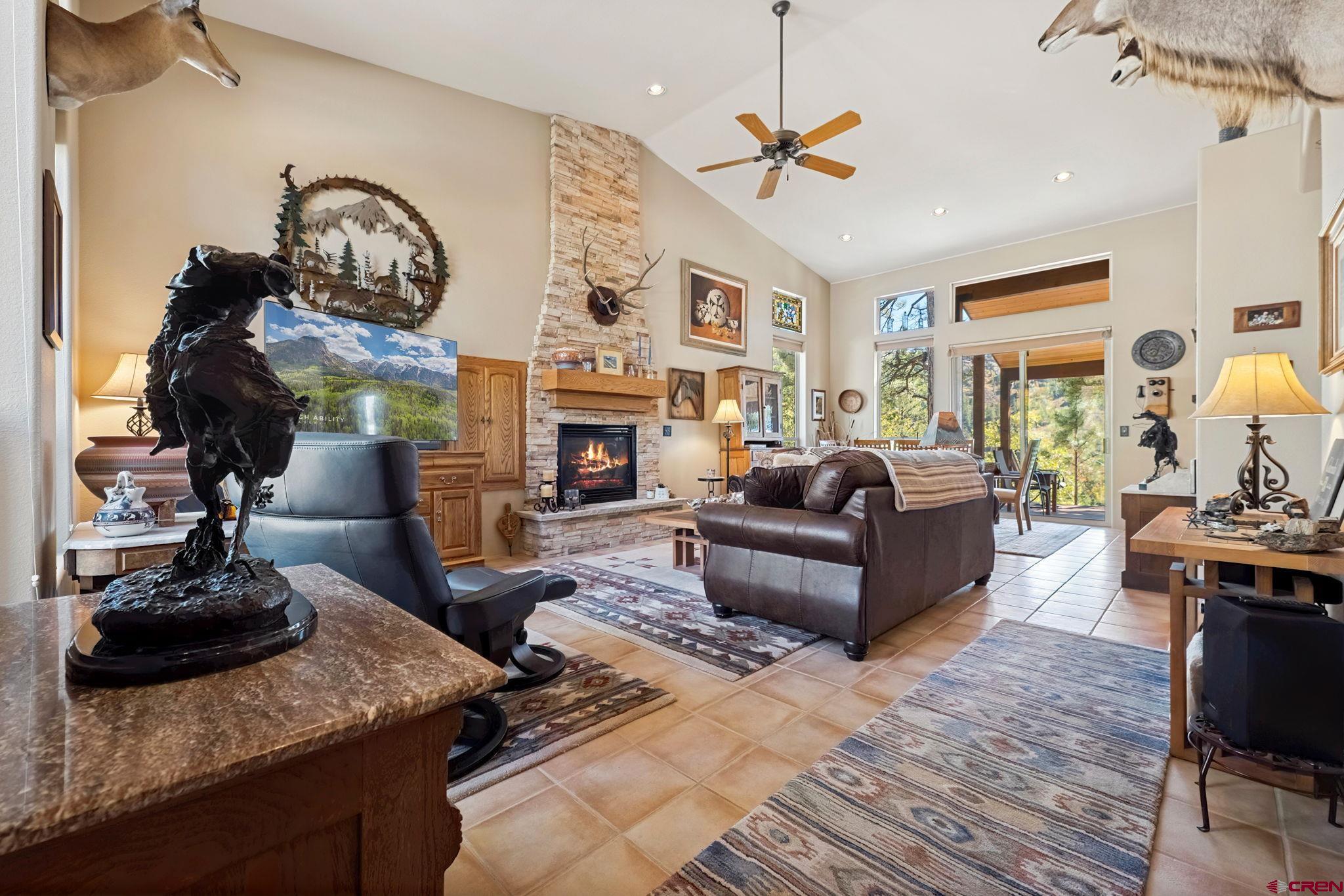 55 Edgemont Way Durango, CO 81301 - Photo 2 of 27 a living room with furniture a fireplace and a chandelier
