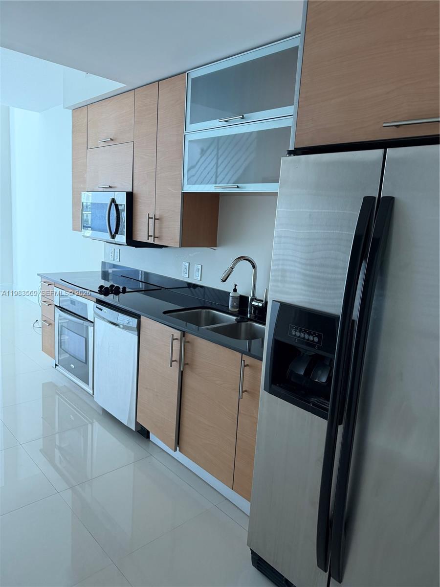 60 Southwest 13th Street, Unit 1806 Miami, FL 33130 - Photo 6 of 12 a kitchen with a sink and a stove top oven