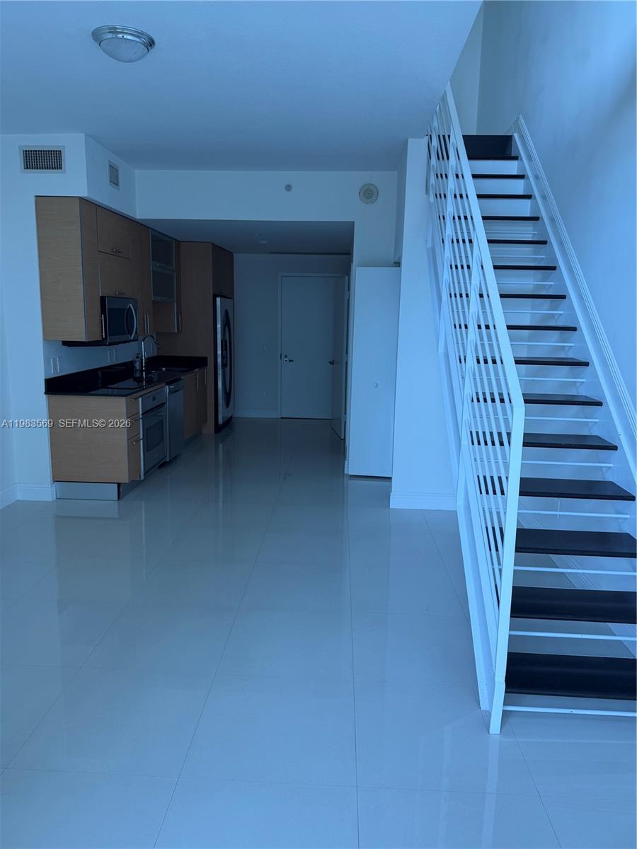 60 Southwest 13th Street, Unit 1806 Miami, FL 33130 - Photo 7 of 12 a view of a livingroom with furniture and staircase