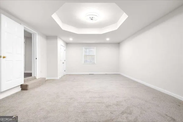 an empty room with a window and closet area
