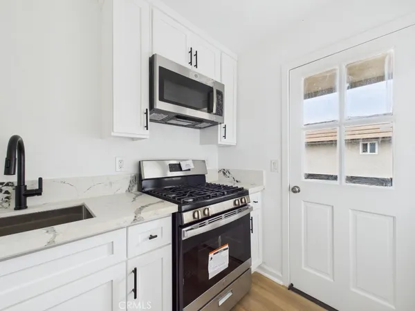 a kitchen with stainless steel appliances a stove a microwave and sink