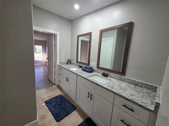 a bathroom with a double vanity sink and a mirror