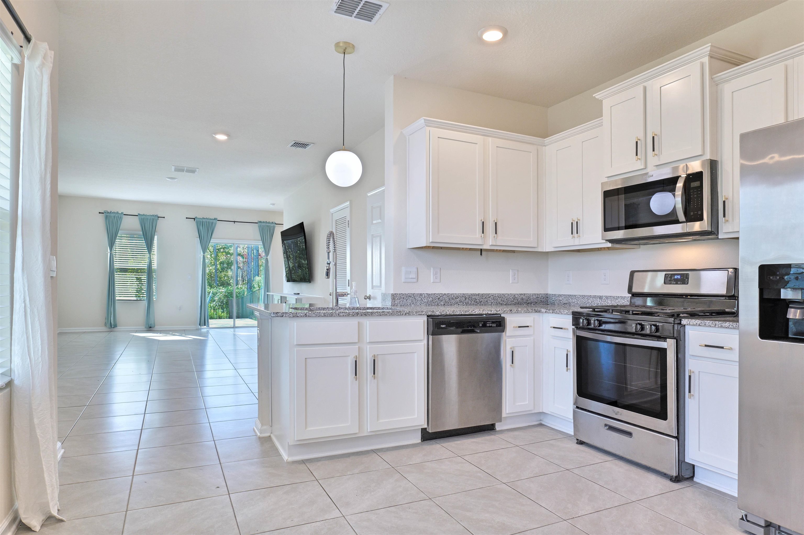 297 Coastline Way Street St. Augustine, FL 32092 - Photo 36 of 36 a kitchen with stainless steel appliances granite countertop a stove a sink and a microwave