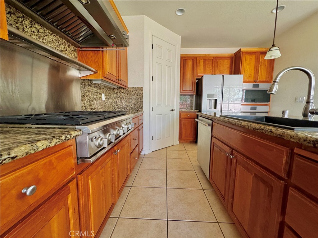 129 Walker Ranch Parkway Patterson, CA 95363 - Photo 6 of 7 a kitchen with stainless steel appliances granite countertop a stove a sink and a refrigerator