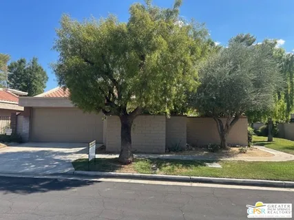 a view of a house with a yard and large tree