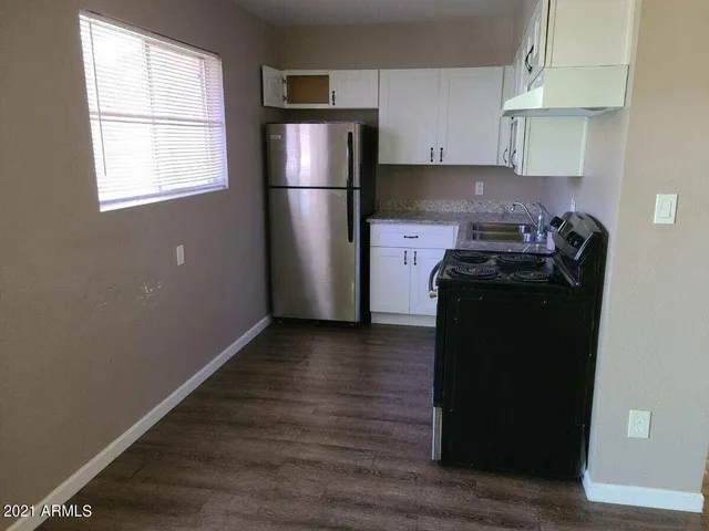 a kitchen with a refrigerator and a stove