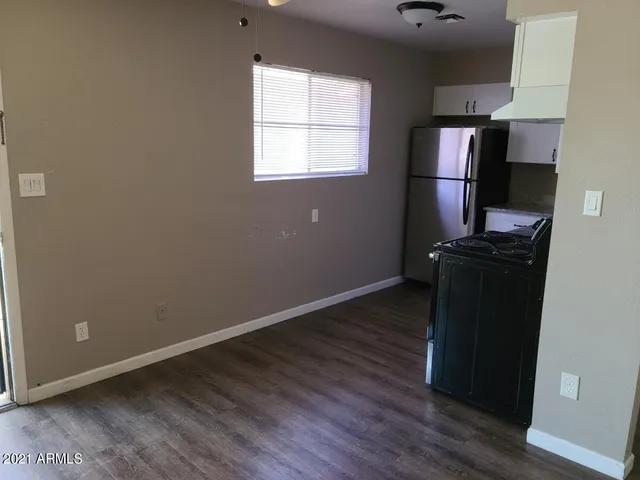 an empty room with wooden floor and a window