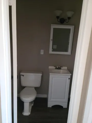 a bathroom with a toilet sink and mirror