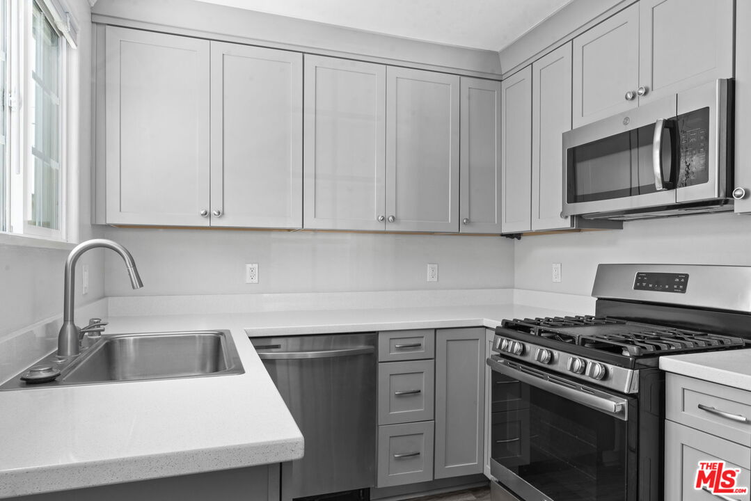 1960 North Ontario Street Burbank, CA 91505 - Photo 8 of 16 a kitchen with stainless steel appliances granite countertop white cabinets a stove top oven with a sink and dishwasher