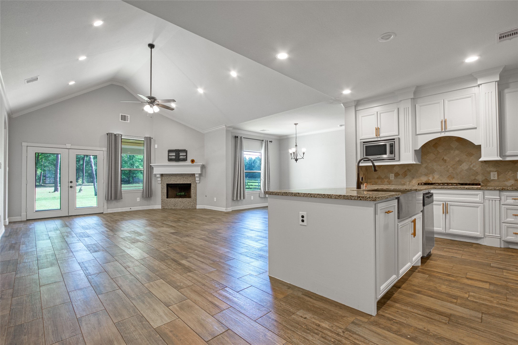 27684 Rio Blanco Drive Splendora, TX 77372 - Photo 8 of 31 a open kitchen with stainless steel appliances granite countertop a stove top oven a sink dishwasher a dining table and chairs with wooden floor