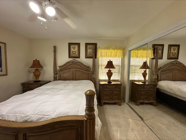 a bedroom with a bed and dresser with mirror