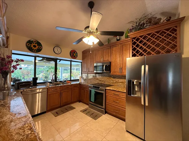 a kitchen with stainless steel appliances granite countertop a stove a sink and a refrigerator