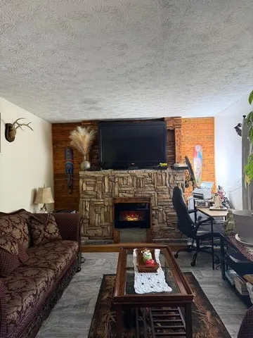 a living room with furniture a fireplace and a flat screen tv