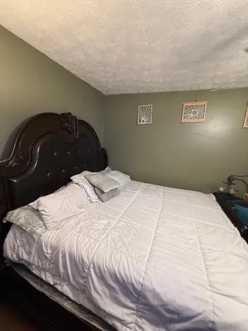 a bedroom with a bed and a night stand