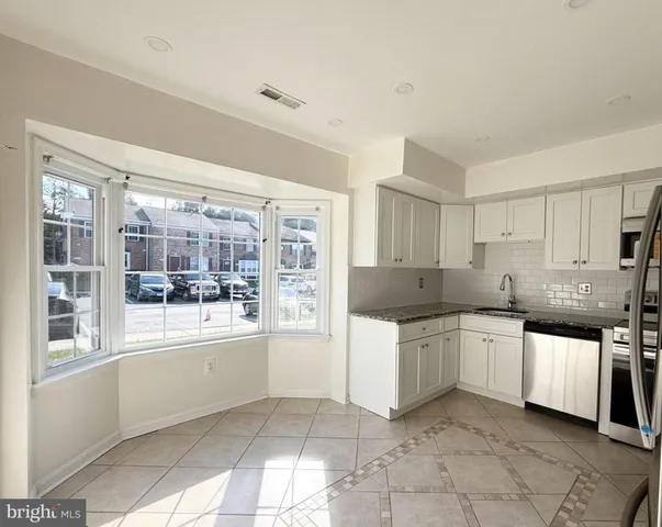 a kitchen with stainless steel appliances a sink window and cabinets