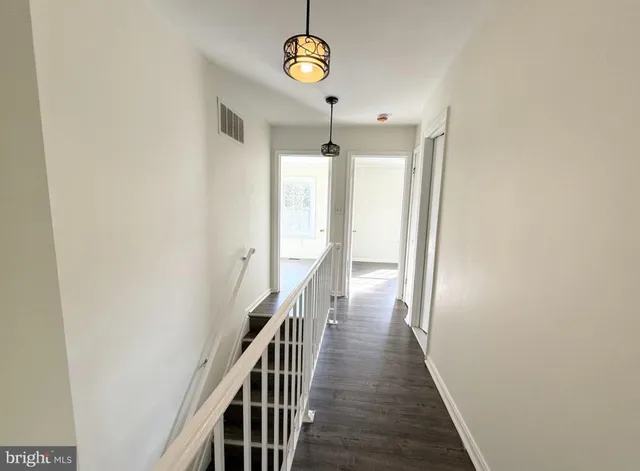 a view of a hallway with wooden floor and entryway