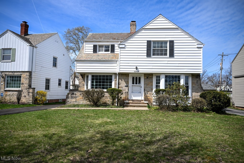 2284 Traymore Road Cleveland, OH 44118 - Photo 1 of 19 View of front of home featuring stone siding, a chimney, and a front lawn