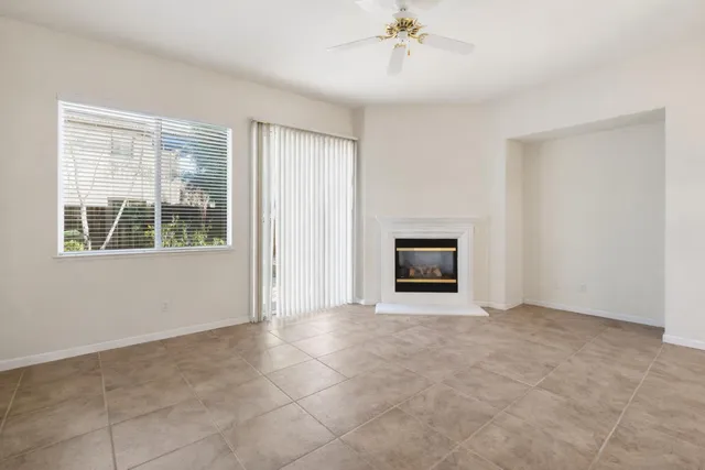 a view of an empty room with window and fire place
