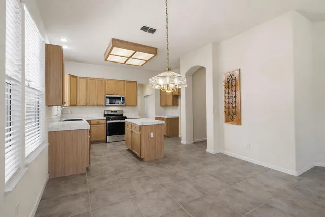 a large kitchen with kitchen island a sink stainless steel appliances and cabinets