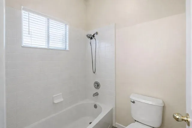 a bedroom with a bed and a potted plant on dresser