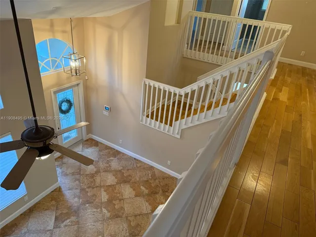a view of a hallway with wooden floor and stairs