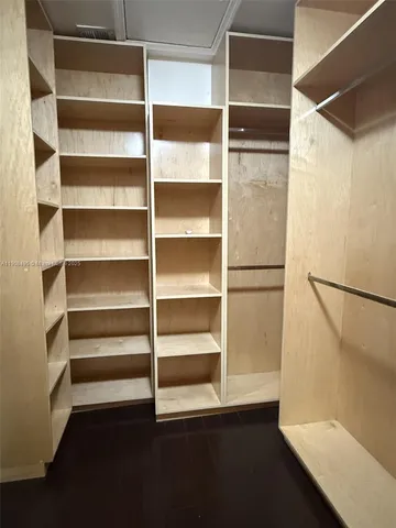 a view of walk in closet with empty racks