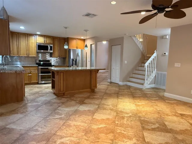 a view of kitchen with stainless steel appliances granite countertop lots of counter top space