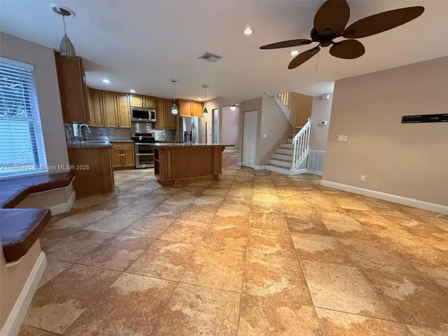 a view of kitchen with furniture and a ceiling fan