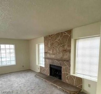 2813 Cacto Court Henderson, NV 89074 - Photo 27 of 28 Unfurnished living room featuring a fireplace, carpet, and a textured ceiling