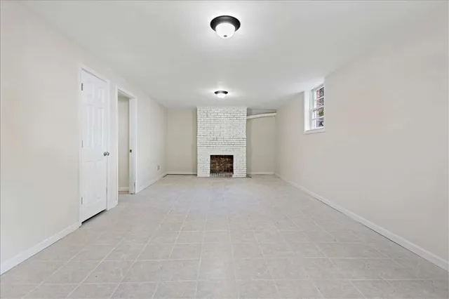an empty room with fireplace and windows
