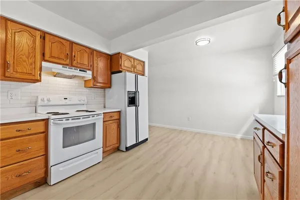 a kitchen with a stove cabinets and a wooden floor