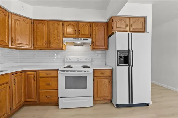 a kitchen with stainless steel appliances granite countertop a refrigerator and a stove top oven
