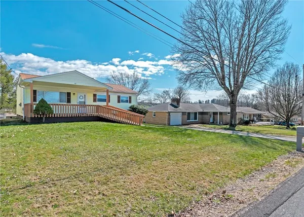 a front view of a house with garden and trees