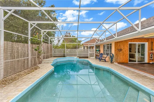 a view of a backyard with table and chairs and large trees