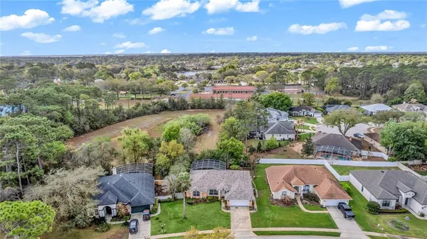 an aerial view of a swimming pool with outdoor seating and yard