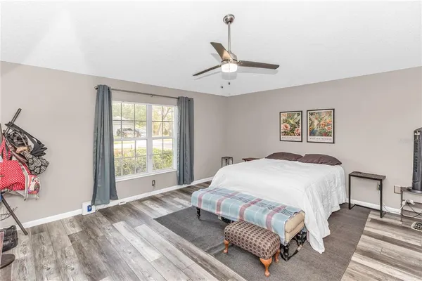 a spacious bedroom with a bed and a chandelier