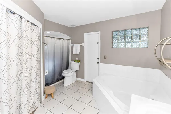 a spacious bathroom with a bathtub sink and mirror