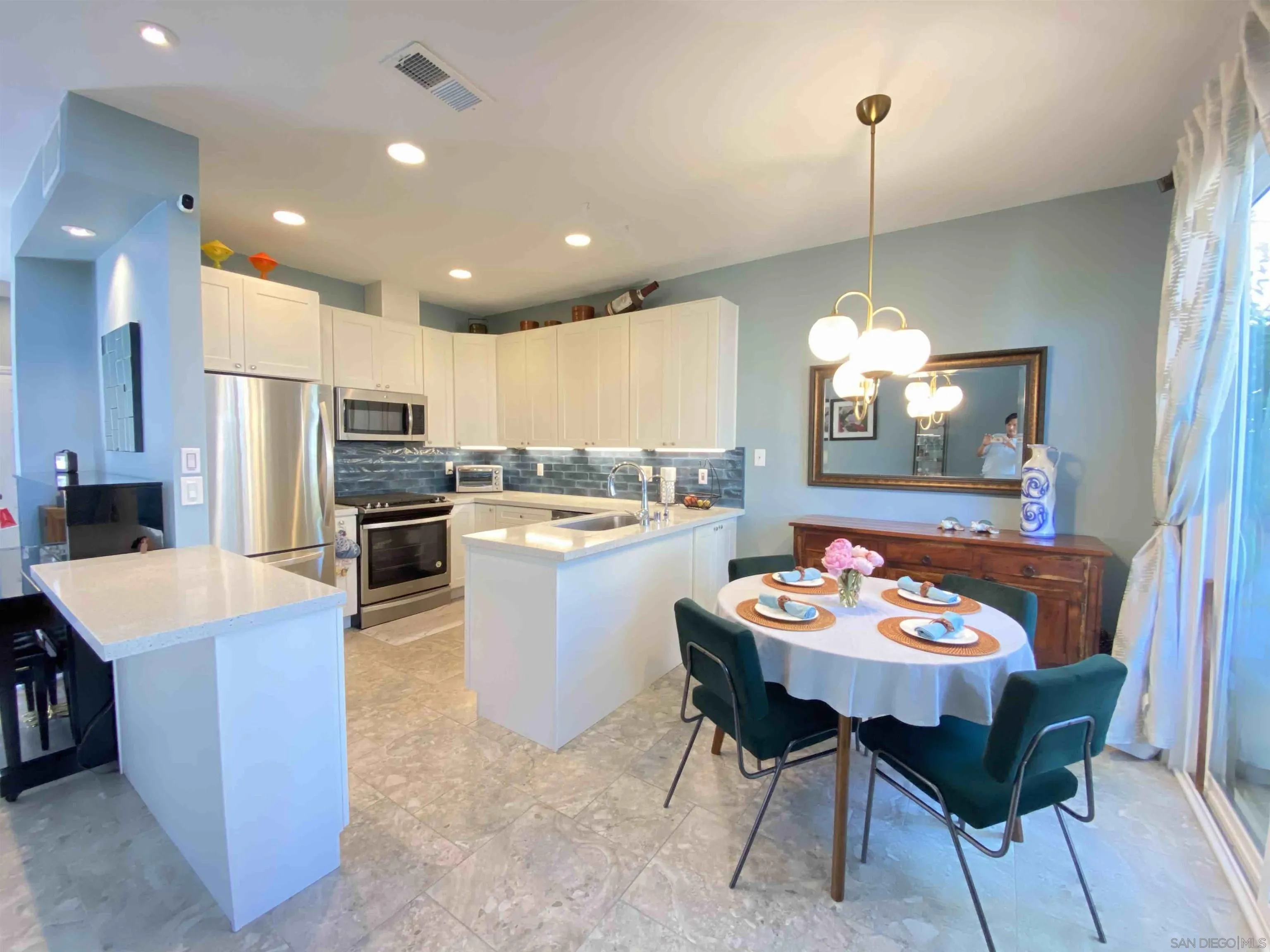 13319 Kibbings Road San Diego, CA 92130 - Photo 12 of 32 a kitchen with a dining table chairs and refrigerator