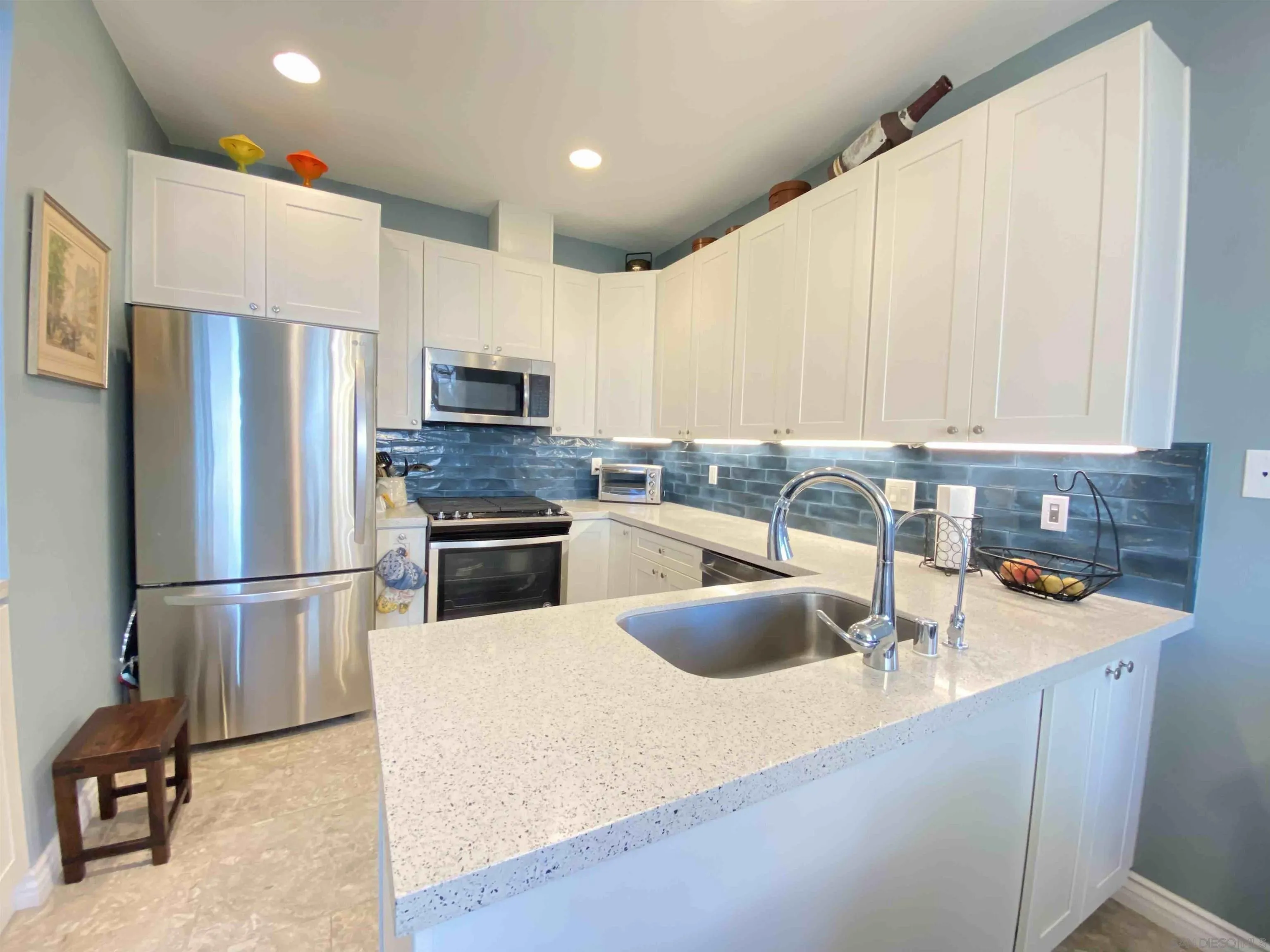 13319 Kibbings Road San Diego, CA 92130 - Photo 13 of 32 a kitchen with stainless steel appliances granite countertop a sink a stove a refrigerator a washer dryer and a refrigerator