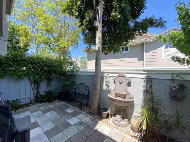 a view of a patio with table and chairs potted plants and a large tree