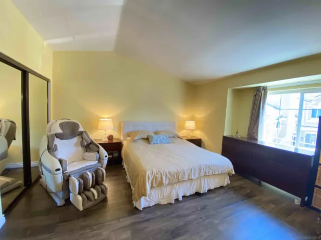 a bedroom with two beds and wooden floor