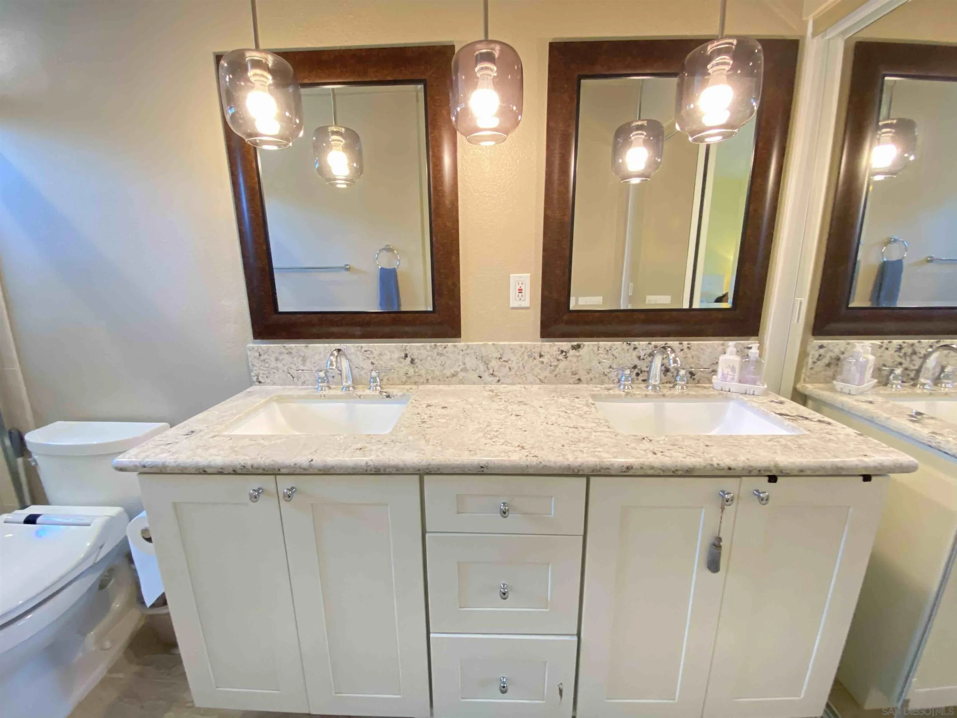 13319 Kibbings Road San Diego, CA 92130 - Photo 26 of 32 a bathroom with a granite countertop sink and a mirror