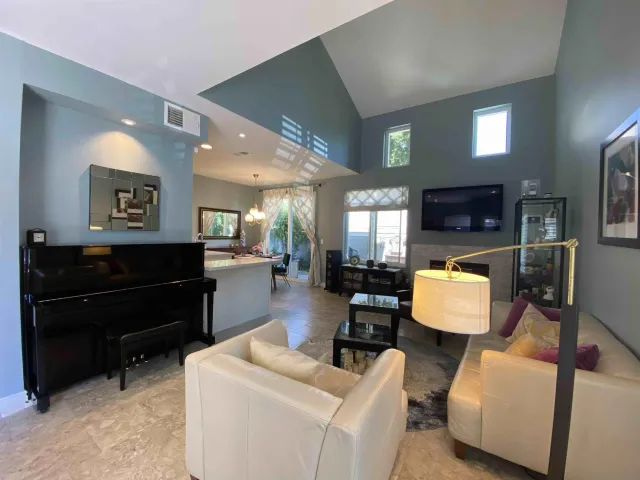 a living room with furniture and a flat screen tv with kitchen view