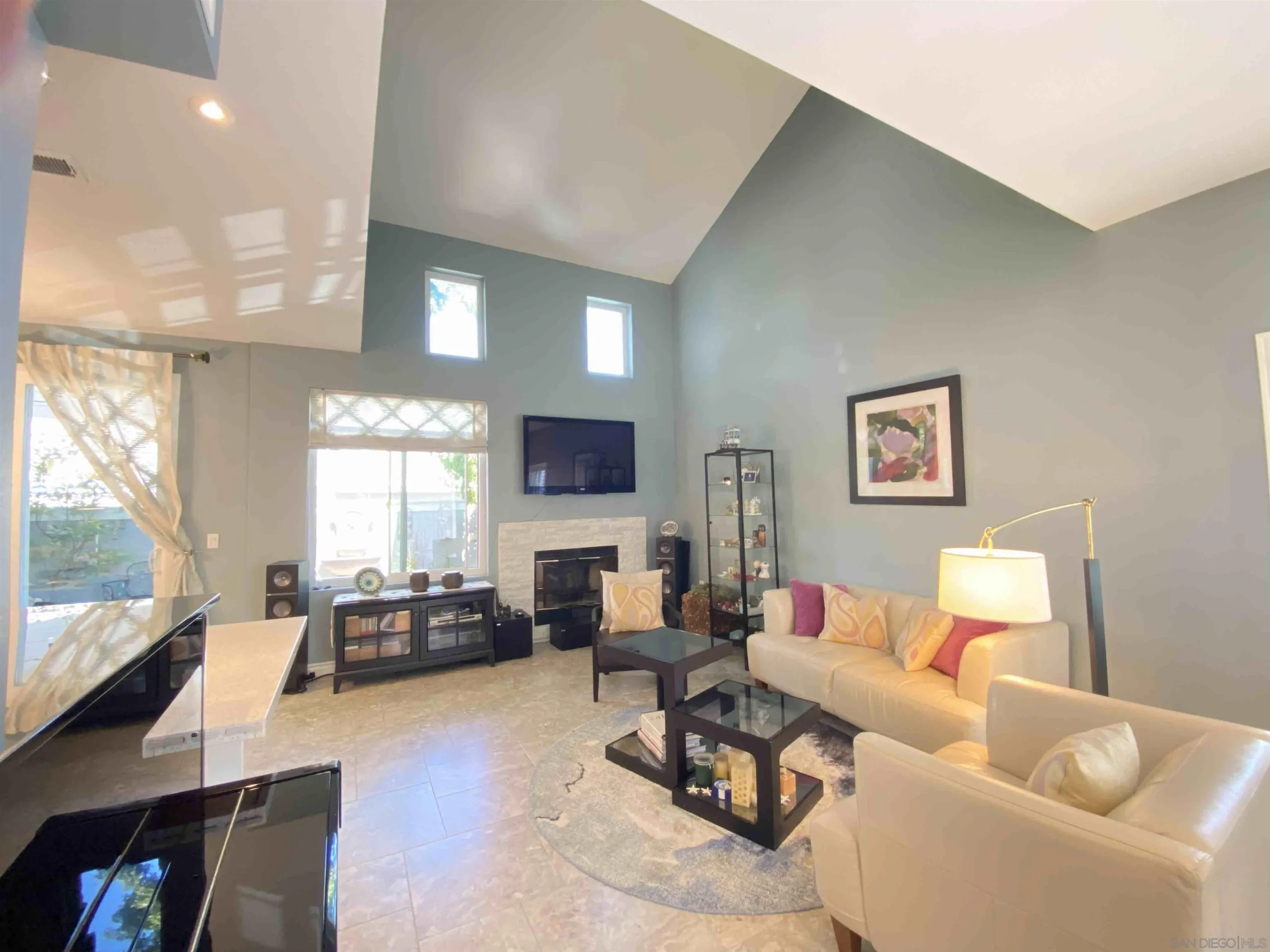 13319 Kibbings Road San Diego, CA 92130 - Photo 10 of 32 a living room with furniture flat screen tv and a large window