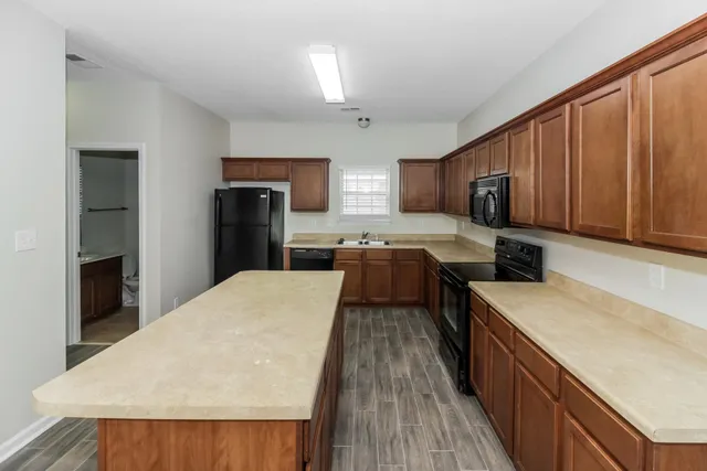 a kitchen with stainless steel appliances granite countertop wooden cabinets a stove top oven a sink and dishwasher