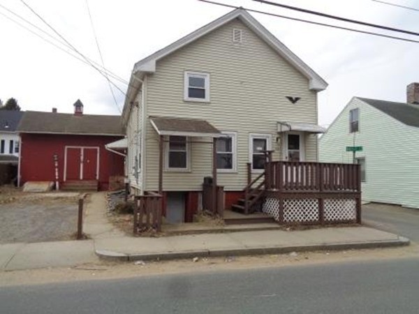 a view of a house with a patio and a yard